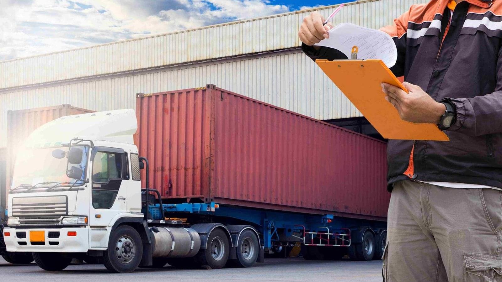 A person inspection a truck parked in a warehouse or loading dock